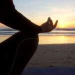 devojka izvodi mantru na plaži