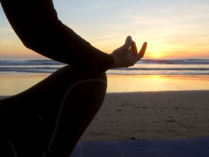 devojka izvodi mantru na plaži