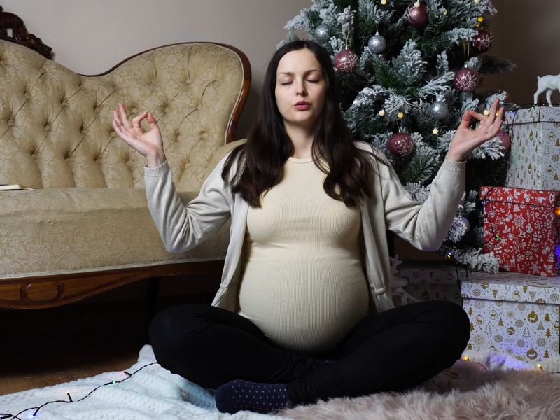 trudnica radi jogu u dnevnoj sobi